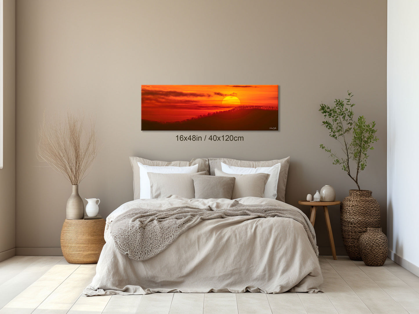 16x48 inch Radiant Hope fine art print mounted above a bed in a serene bedroom setting, capturing the morning light over bare trees and mountain ridges.