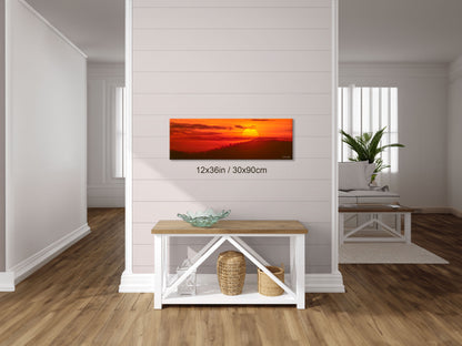 12x36 inch Radiant Hope fine art print displayed in a hallway above a console table, featuring the vivid orange and red hues of sunrise over the Blue Ridge Mountains.