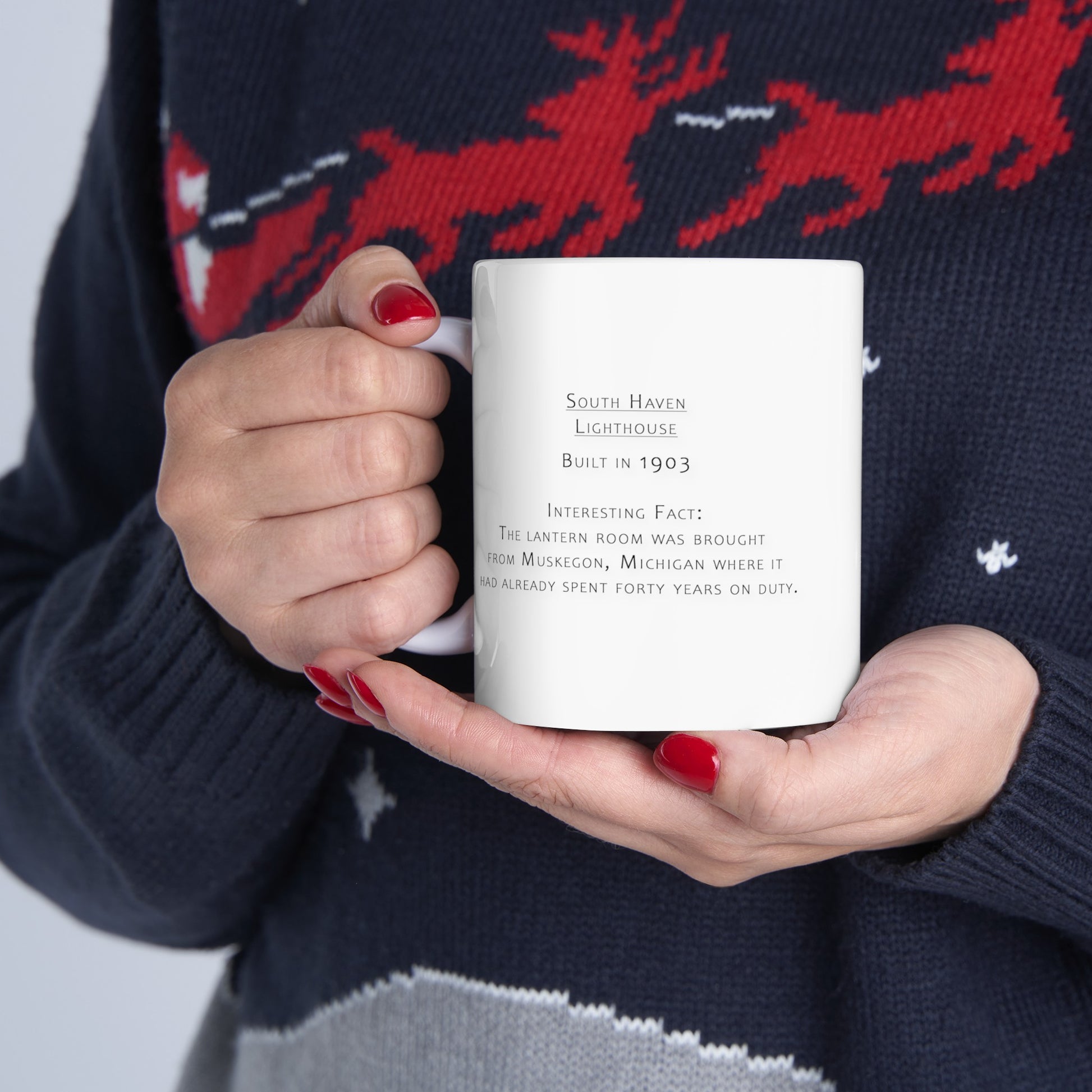 Person holding South Haven Lighthouse ceramic mug by Dennis Caskey