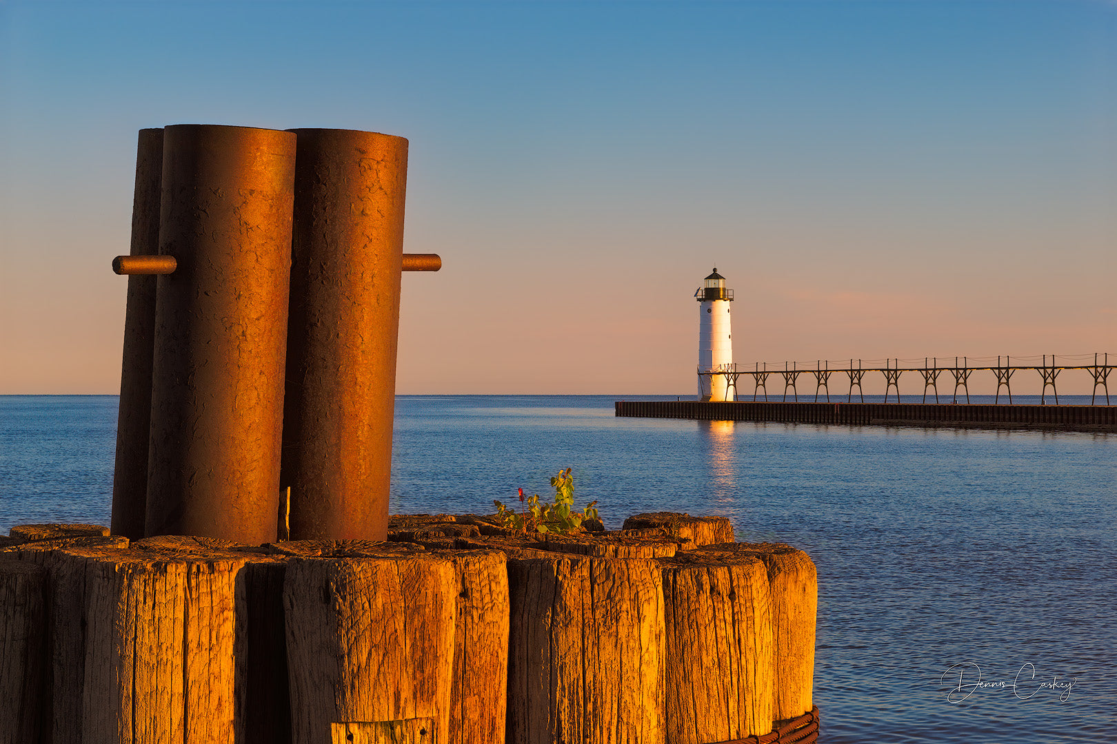 Mooring dolphin and Manistee lighthouse stock photo by Dennis Caskey